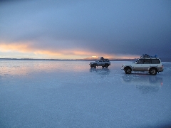   Zoom : Coucher du soleil sur le lac de sel de Uyuni au pied d'un volcan.  